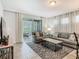 Bright living room featuring a comfortable couch, stylish rug, and sliding glass doors to the outdoor pool area at 5255 Wildwood Way, Davenport, FL 33837