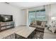 Cozy living room with a view of the screened-in pool, a comfortable couch, and a stylish entertainment center at 5255 Wildwood Way, Davenport, FL 33837