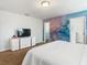 This is a large main bedroom with artistic wallpaper accent and modern dresser at 5255 Wildwood Way, Davenport, FL 33837