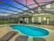 Tranquil backyard with a screened-in pool, spa, and lounge area, perfect for outdoor relaxation and entertaining at 5255 Wildwood Way, Davenport, FL 33837