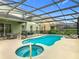 Enjoy the Florida lifestyle in this screened-in pool and spa with a serene backyard at 5255 Wildwood Way, Davenport, FL 33837