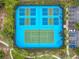 Overhead shot of well-maintained tennis courts surrounded by lush greenery and convenient parking at 5255 Wildwood Way, Davenport, FL 33837