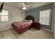 Inviting bedroom featuring wood floors, an accent wall, and plenty of natural light from two windows at 5515 Paradise Cay Cir, Kissimmee, FL 34746