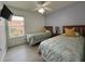 Cozy bedroom with twin beds, ceiling fan, laminate flooring, and natural light from a window at 5515 Paradise Cay Cir, Kissimmee, FL 34746