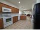 Well-equipped kitchen features white appliances, wooden cabinets, and view into the adjacent living spaces at 5515 Paradise Cay Cir, Kissimmee, FL 34746