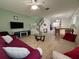 Open concept living room with tile flooring, a ceiling fan, and a view to the kitchen and staircase at 5515 Paradise Cay Cir, Kissimmee, FL 34746