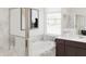 Modern bathroom with a soaking tub, marble tile surround, framed art and natural light at 5656 Vinyasa Rd, Clermont, FL 34714