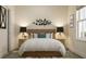 Comfortable bedroom with a wooden headboard, side tables with lamps, and minimalist decor at 5656 Vinyasa Rd, Clermont, FL 34714