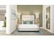 Inviting bedroom featuring a bed with neutral bedding, decorative pillows, side tables and artwork at 5656 Vinyasa Rd, Clermont, FL 34714