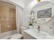 Charming bathroom with a round mirror, white vanity, tub, and white orchids at 602 E Livingston St # 3, Orlando, FL 32803