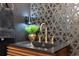 Close-up on the bathroom vanity showcasing the gold faucet, designer backsplash, and modern lighting at 602 E Livingston St # 3, Orlando, FL 32803
