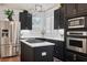 Modern kitchen features stainless steel appliances, an island cooktop, and sleek dark cabinets at 602 E Livingston St # 3, Orlando, FL 32803
