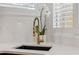 Kitchen sink with designer gold faucet and black basin, white quartz countertop, and white orchids at 602 E Livingston St # 3, Orlando, FL 32803