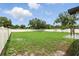 Spacious backyard featuring green grass, white fence, and string lights at 7307 Grace Rd, Orlando, FL 32819