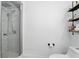 Bathroom features a walk-in shower, modern fixtures and decorative shelving for storage at 7307 Grace Rd, Orlando, FL 32819
