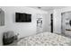 Light and airy bedroom featuring wood-look floors, TV, an open closet, and view to kitchen through the doorway at 7307 Grace Rd, Orlando, FL 32819