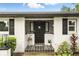 Elegant front entrance with a decorative black door, patterned tile landing, and white brick exterior at 7307 Grace Rd, Orlando, FL 32819