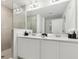 Modern bathroom featuring double vanity, framed mirrors, and tiled shower at 746 Longboat Dr, Davenport, FL 33896