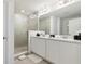 Modern bathroom with double sink vanity, framed mirrors, and a glass-enclosed shower at 746 Longboat Dr, Davenport, FL 33896