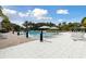 Expansive community pool with ample seating, shade umbrellas, and lush green surroundings for a serene setting at 746 Longboat Dr, Davenport, FL 33896