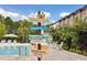 Resort-style pool area with a playful signpost, comfortable lounge chairs, and lush tropical landscaping at 746 Longboat Dr, Davenport, FL 33896