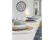 Close-up of a dining table showcasing stylish tableware, a neutral table runner, and a decorative clock on the wall at 746 Longboat Dr, Davenport, FL 33896