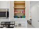 Open kitchen cabinet showcasing organized dishware and colorful glassware at 746 Longboat Dr, Davenport, FL 33896