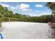 A bright, sunny sand volleyball court surrounded by lush landscaping at 746 Longboat Dr, Davenport, FL 33896
