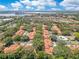 An aerial view of a neighborhood with orange tile roofs, lush trees, and community pool and waterway at 8035 Bayside View Dr, Orlando, FL 32819