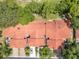 An overhead shot showcases a community with orange tile roofs surrounded by mature trees, lawns and driveways at 8035 Bayside View Dr, Orlando, FL 32819