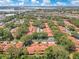 A high-angle shot featuring rooftops with orange tile in a mature planned community with lush trees and a large waterway at 8035 Bayside View Dr, Orlando, FL 32819
