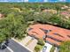 Birds eye view featuring orange tile roofs with mature trees, well-manicured lawns and paved driveways and roadways at 8035 Bayside View Dr, Orlando, FL 32819