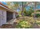 A serene backyard showcases green grass, a large tree, and a patio area accessible through a screened door at 8035 Bayside View Dr, Orlando, FL 32819