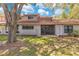 Backyard view of the property featuring a patio and an expansive lawn under a cloudy sky at 8035 Bayside View Dr, Orlando, FL 32819