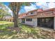 The backyard of the property showcases a patio and large lawn space beneath a partly cloudy sky at 8035 Bayside View Dr, Orlando, FL 32819