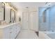 Bright bathroom featuring double vanity with a marble countertop and walk-in shower with glass door at 8035 Bayside View Dr, Orlando, FL 32819
