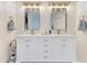 Bathroom featuring dual sinks, vanity with white cabinets, and decorative mirrors and lighting at 8035 Bayside View Dr, Orlando, FL 32819