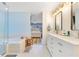 A spacious bathroom featuring double sinks, a soaking tub and view through to the Primary bedroom at 8035 Bayside View Dr, Orlando, FL 32819