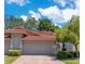 Charming villa showcasing a red tile roof, lush landscaping, and a well-maintained exterior at 8035 Bayside View Dr, Orlando, FL 32819