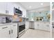 Modern kitchen with stainless steel appliances, white cabinetry, and a view into the Gathering room at 8035 Bayside View Dr, Orlando, FL 32819