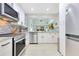 Modern kitchen with stainless steel appliances, white cabinetry, and a view into the Gathering room at 8035 Bayside View Dr, Orlando, FL 32819