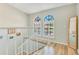 A staircase with hardwood steps and white railing leads to a landing with arched windows at 8035 Bayside View Dr, Orlando, FL 32819