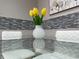 Close-up of the glass dining table, featuring yellow tulips in a white decorative vase at 8035 Bayside View Dr, Orlando, FL 32819