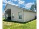 View of the home's rear exterior with a covered patio and green lawn at 807 Knightsbridge Cir, Davenport, FL 33896