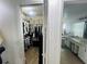 A well-organized walk-in closet featuring clothing racks, shelving, and a glimpse into an adjacent updated bathroom at 807 Knightsbridge Cir, Davenport, FL 33896