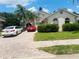 Inviting home featuring a brick driveway, manicured lawn, and tropical landscaping at 807 Knightsbridge Cir, Davenport, FL 33896