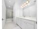 Bright, updated bathroom featuring a white vanity, marble flooring, and glass-enclosed shower at 8085 Ludington Cir, Orlando, FL 32836