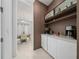 Stylish butler's pantry featuring custom shelving, display cabinets, and counter space with modern appliances at 8085 Ludington Cir, Orlando, FL 32836