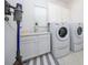 Well-lit laundry room with a washer, dryer, storage cabinets, and a utility sink at 8085 Ludington Cir, Orlando, FL 32836