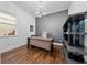 Modern office with wood floors, a large desk, and stylish shelving with natural light from the window at 8085 Ludington Cir, Orlando, FL 32836